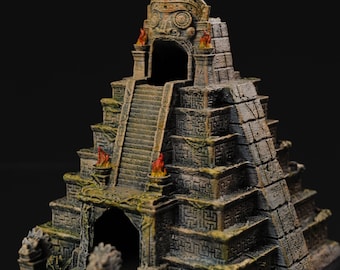 May include: A miniature, multi-level, stone temple with a carved face at the top. The temple has a dark green base and a green die inside. The temple is made of plastic and is painted in shades of brown, green, and red.