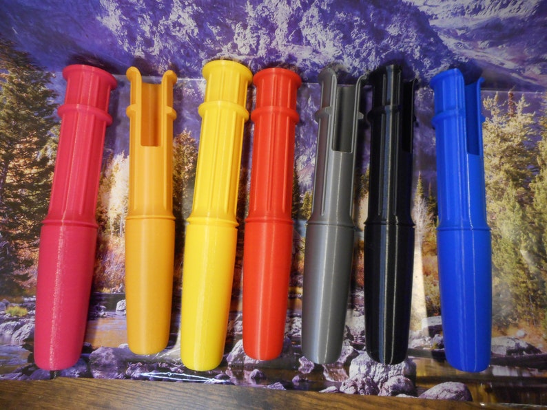 Op de afbeelding: Zeven kleurrijke plastic buizen met een gespleten opening aan de bovenkant. De buizen zijn rood, oranje, geel, rood, grijs, zwart en blauw.