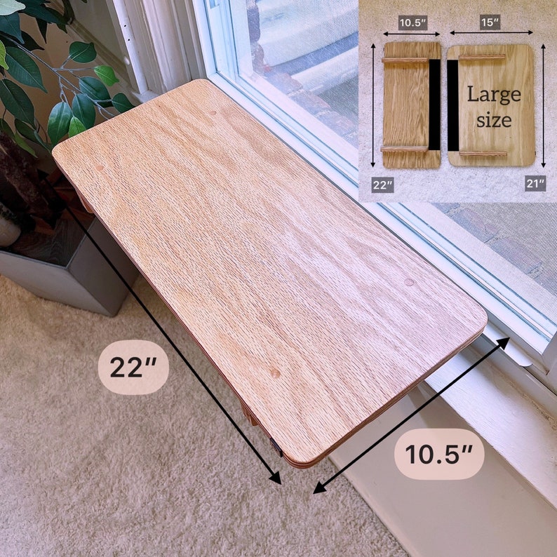 K&ouml;nnte beinhalten: Ein Holz-Fensterbrett, 56 cm lang und 27 cm breit, montiert auf einem Fenstersims. Das Brett ist aus hellem Holz mit nat&uuml;rlicher Maserung. Das Brett ist als Katzenliege oder kleiner Pflanzenst&auml;nder gedacht.