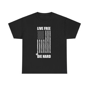 Può includere: Maglietta nera con una bandiera americana bianca usurata e il testo "Live Free or Die Hard".