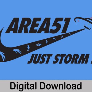 May include: A black and white graphic design featuring a Nike swoosh with the text "AREA 51 JUST STORM IT."  A UFO is flying above the swoosh with small alien figures running along the swoosh.