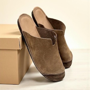 Handmade leather slip-on mules crafted in timeless black and cream colors. Made from genuine leather with a rustic, natural texture, these unisex shoes combine comfort and durability for everyday wear. Available in EU sizes 38–43, but please note: sizing runs small (example: EU 38 fits closer to EU 40). Perfect for summer outfits with jeans or shorts, they are stylish, breathable, and versatile for men and women who value artisan quality.