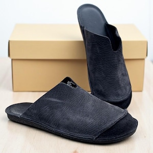 Handmade leather slip-on mules crafted in timeless black and cream colors. Made from genuine leather with a rustic, natural texture, these unisex shoes combine comfort and durability for everyday wear. Available in EU sizes 38–43, but please note: sizing runs small (example: EU 38 fits closer to EU 40). Perfect for summer outfits with jeans or shorts, they are stylish, breathable, and versatile for men and women who value artisan quality.