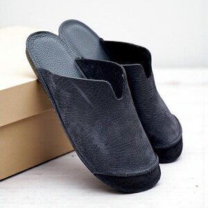 Handmade leather slip-on mules crafted in timeless black and cream colors. Made from genuine leather with a rustic, natural texture, these unisex shoes combine comfort and durability for everyday wear. Available in EU sizes 38–43, but please note: sizing runs small (example: EU 38 fits closer to EU 40). Perfect for summer outfits with jeans or shorts, they are stylish, breathable, and versatile for men and women who value artisan quality.