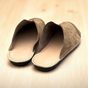 Handmade leather slip-on mules crafted in timeless black and cream colors. Made from genuine leather with a rustic, natural texture, these unisex shoes combine comfort and durability for everyday wear. Available in EU sizes 38–43, but please note: sizing runs small (example: EU 38 fits closer to EU 40). Perfect for summer outfits with jeans or shorts, they are stylish, breathable, and versatile for men and women who value artisan quality.