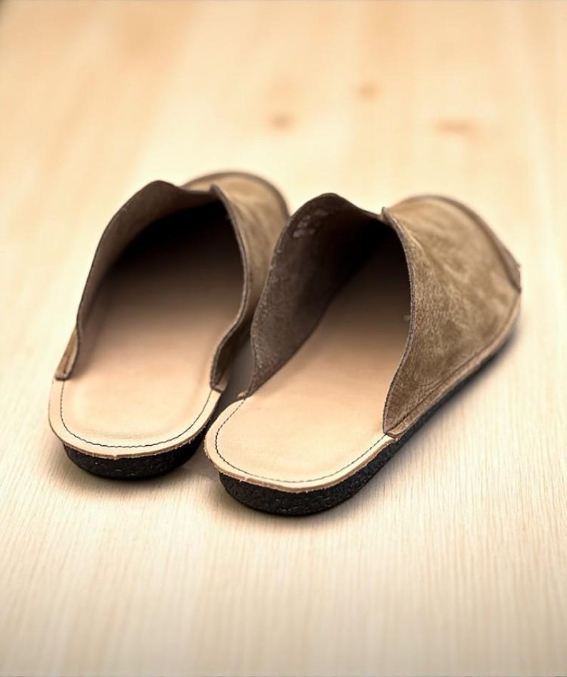 Handmade leather slip-on mules crafted in timeless black and cream colors. Made from genuine leather with a rustic, natural texture, these unisex shoes combine comfort and durability for everyday wear. Available in EU sizes 38–43, but please note: sizing runs small (example: EU 38 fits closer to EU 40). Perfect for summer outfits with jeans or shorts, they are stylish, breathable, and versatile for men and women who value artisan quality.