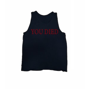 May include: A black tank top with the words "YOU DIED" printed in red across the chest. The sleeveless shirt is made of a soft material and is suitable for casual wear. The text is in a bold, sans-serif font.