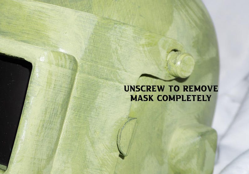 May include: A green welding mask with a screw that needs to be unscrewed to remove the mask completely. The text "UNSCREW TO REMOVE MASK COMPLETELY" is printed on the mask.
