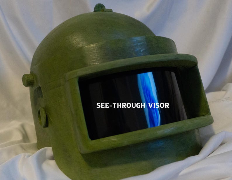 May include: A green helmet with a see-through visor. The visor has the text "SEE-THROUGH VISOR" printed on it.
