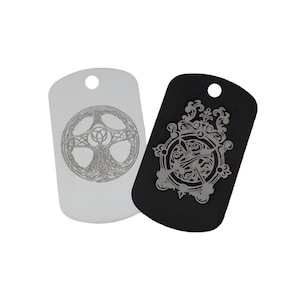May include: Two silver dog tags with different engraved designs. One tag is black and features a compass with arrows and intricate details. The other tag is silver and features a tree of life design with Celtic knotwork.