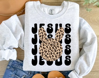 May include: A gray sweatshirt with a black and white graphic of the word "JESUS" with a leopard print bunny in the middle.