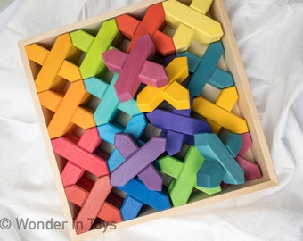 May include: Wooden puzzle with colorful, interlocking pieces in a square wooden tray. The pieces are painted in various colors, including red, orange, yellow, green, blue, and purple. The puzzle is designed for children.