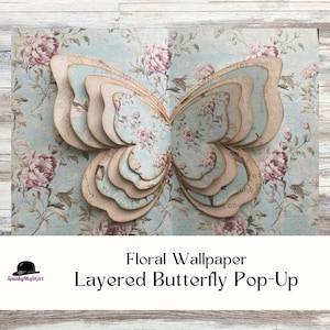 May include: A layered butterfly pop-up made of paper, featuring a floral design with pink roses and a light blue background. The butterfly has multiple layers, creating a 3D effect. The text reads "Floral Wallpaper Layered Butterfly Pop-Up".