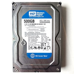 May include: A silver Western Digital 500GB hard drive with a blue label. The label includes the text "WD Caviar Blue" and "www.westerndigital.com". The drive has a SATA interface and a 16MB cache.