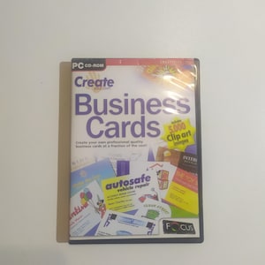 Könnte beinhalten: Ein blaues CD-ROM-Gehäuse mit dem Titel "Create Your Own Business Cards" in weißer Schrift. Das Gehäuse zeigt ein farbenfrohes Design mit verschiedenen Beispielen für Visitenkarten und den Text "Includes 5,000 Clip Art Images".