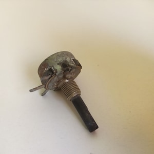 May include: A silver and black potentiometer with a round knob and a black shaft. The knob has six slots around the edge.