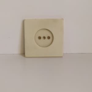 May include: A white electrical outlet with three round holes.