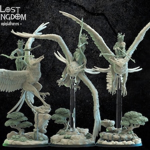 May include: Three miniature fantasy figures of winged creatures with riders, displayed on stands. The figures are light gray, with detailed wings and features. The base of each figure includes miniature trees and rock formations. The Lost Kingdom miniatures logo is in the upper left.
