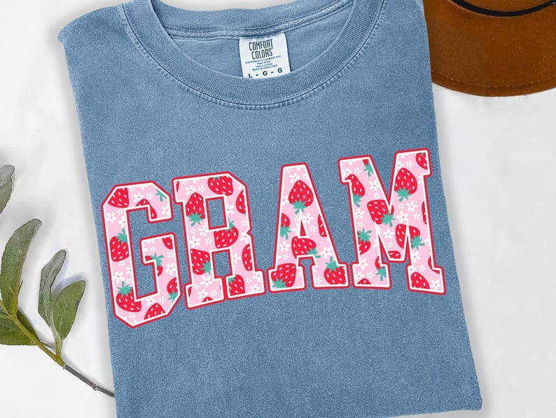 Strawberry-themed retro varsity style Mother's Day PNG shirt designs for sublimation, featuring Mama, Momma, Mini, Gigi, Gram, and Lita in pink red floral fruit print on white t-shirts, digital files for Cricut and heat press crafting, perfect for Mother's Day gifts and matching family outfits on Etsy.