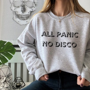 May include: Grey sweatshirt with the text "ALL PANIC NO DISCO" printed in black.