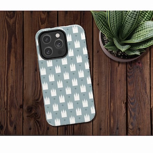 May include: A blue phone case with a white repeating pattern of church buildings. The case has a camera lens cutout.