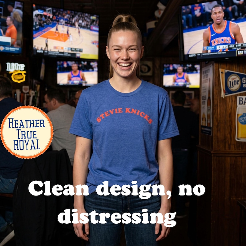 Puede incluir: Una camiseta de manga corta en color azul real jaspeado con el texto STEVIE KNICKS impreso en naranja en el pecho. La prenda cuenta con un cuello redondo y un acabado limpio, sin efecto desgastado, para un aspecto sencillo.
