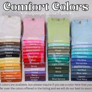 May include: A display of folded Comfort Colors heavyweight unisex t-shirts in various colors, including white, pink, green, and blue. The image features a color chart with names like "Blossom," "Lagoon Blue," and "True Navy."