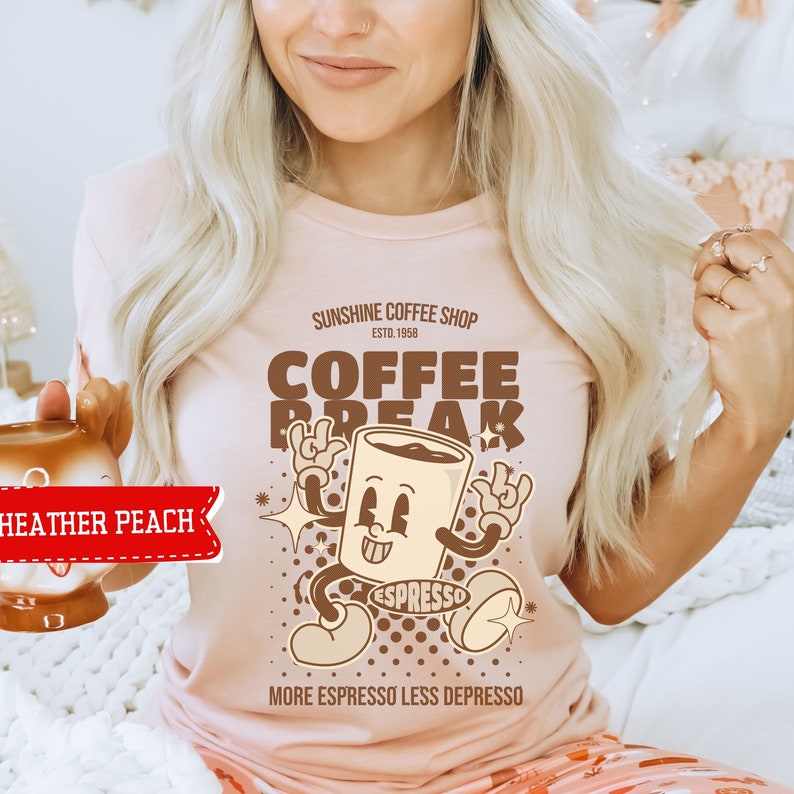 May include: A pink t-shirt with a brown cartoon coffee cup graphic. The text on the shirt reads "Sunshine Coffee Shop Est. 1958 Coffee Break More Espresso Less Depresso".