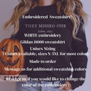 May include: Black sweatshirt with white embroidery that reads "They Missed One Salem, 1692". The sweatshirt is being held by a person and a pumpkin is in the foreground. The text "Unisex Sizing 5 Colors available, sizes S-5XL for most colors Made to order Message us for additional sweatshirt colors Message us if you would like to change the color of the embroidery!" is also visible on the sweatshirt.