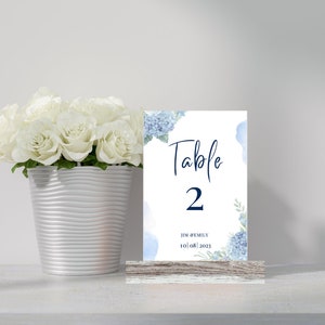 Może przedstawiać: Błękitna i biała karta numeru stołu z tekstem "Stół 2" i datą "10.08.2023".