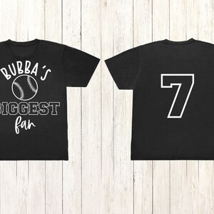Peut inclure: Deux t-shirts noirs. L'un porte le texte "Bubba's Biggest fan" avec un graphique de baseball. L'autre porte le num&eacute;ro "7" au dos.