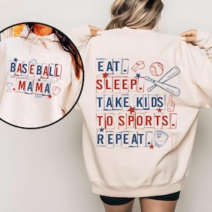 May include: Cream-colored sweatshirt with baseball-themed graphics. The front features "Baseball Mama" in red and blue block letters with baseball icons. The back says "Eat Sleep Take Kids To Sports Repeat" with baseball and star illustrations.