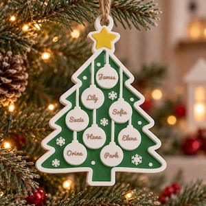 May include: A green Christmas tree-shaped ornament with a white border and a yellow star at the top. It features eight white circular baubles, each inscribed with a name: James, Lily, Sofia, Suzie, Hana, Elena, Orina, and Park.