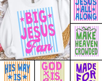 May include: White sweatshirt with the text "BIG JESUS Fan" in pink, set against a backdrop of light blue vertical stripes. Additional graphics include text blocks with phrases like "It Was Jesus All Along".