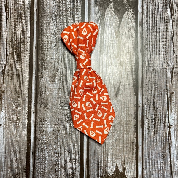 This print features skulls and bones on an orange background and is perfect for Halloween and a great necktie or bow for your dog or cat!