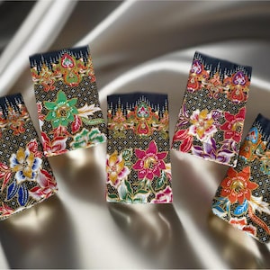 May include: Six small fabric squares with a black background and colorful floral patterns. The fabric squares are arranged in a row on a white surface.