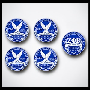 May include: Five circular blue and white emblems featuring a dove graphic, the text ZΦB, and the phrase I AM A ZETA AND A VETERAN. Four emblems specify military branches: AIR FORCE, NAVY, ARMY, and COAST GUARD, while one emblem features the ZΦB logo.
