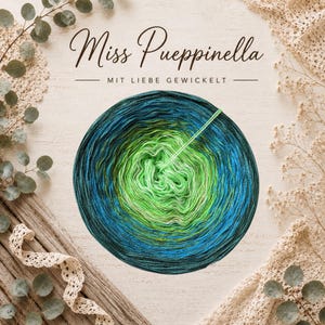 Könnte beinhalten: Ein kreisförmiges Garnknäuel mit einem Farbverlauf von einem hellen Lindgrün in der Mitte bis zu einem tiefen Türkis und Dunkelblau am äußeren Rand. Der Text Miss Pueppinella und MIT LIEBE GEWICKELT steht in dunkler Schreibschrift darüber.