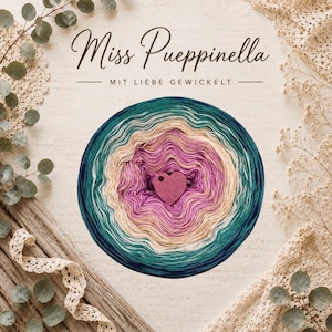 Könnte beinhalten: Ein kreisförmiges Garnknäuel mit einem Farbverlauf von tiefem Petrol und Grün bis hin zu Creme und leuchtendem Magenta, in der Mitte mit einem kleinen lila herzförmigen Anhänger. Der Text Miss Pueppinella und MIT LIEBE GEWICKELT ist über dem Garn aufgedruckt.