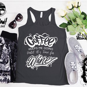 May include: A dark grey tank top with a white graphic that says "Coffee keeps me going until it's time for wine". The graphic is in a graffiti style with drips of paint.