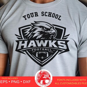 May include: A light gray t-shirt featuring a black and white graphic of an eagle's head within a shield, with the text "YOUR SCHOOL" above and "HAWKS FOOTBALL" below. The shirt includes the text "SVG EPS PNG DXF" and "FONTS INCLUDED WITH ALL CUSTOMIZABLES FILES".