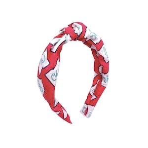 Peut inclure: Un bandeau rouge avec un contour blanc de l'état de l'Ohio et le mot "Ohio" écrit en turquoise. Le bandeau est noué en haut.