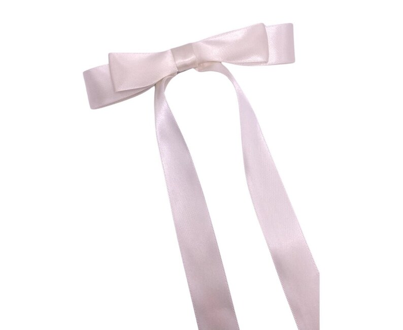 May include: A white satin ribbon bow with two long tails.