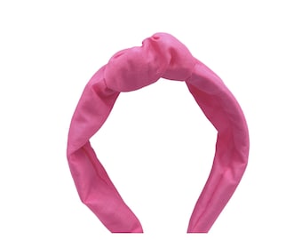 May include: A bright pink knotted headband made of fabric.