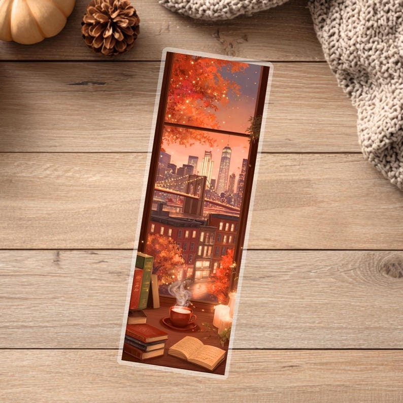 Peut inclure: Marque-page avec une illustration d'un paysage urbain vu &agrave; travers une fen&ecirc;tre. L'&oelig;uvre repr&eacute;sente une sc&egrave;ne chaleureuse avec des livres, une tasse de caf&eacute; et une bougie allum&eacute;e, &eacute;voquant une ambiance automnale.