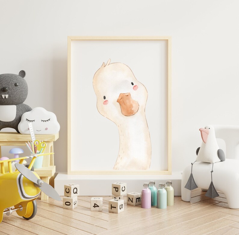 Puede incluir: Una ilustraci&oacute;n de acuarela de un lindo ganso con un pico marr&oacute;n claro y mejillas rosadas. La ilustraci&oacute;n est&aacute; enmarcada y colgada en una pared blanca en una guarder&iacute;a.