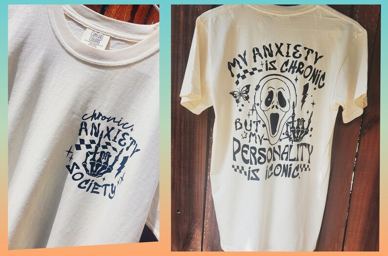 Może przedstawiać: Kremowa koszulka z czarnym tekstem graficznym i ilustracjami. Prz&oacute;d przedstawia "Chronic Anxiety Society" z gestem dłoni. Tył m&oacute;wi "My Anxiety is Chronic But My Personality is Iconic" z maską Scream.