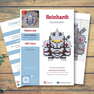 May include: A cross-stitch pattern sheet titled "Reinhardt" featuring a pixel art design of a character. The pattern size is 1.79 x 1.93 inches, with 25 x 27 stitches. Includes DMC color information.