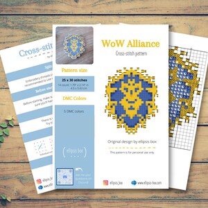 May include: A cross-stitch pattern titled "WoW Alliance" with a blue and yellow geometric design. The pattern size is 25 x 30 stitches, with dimensions of 1.79 x 2.14 inches. The design uses 5 DMC colors. The image includes instructions.