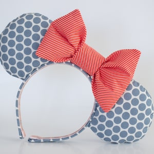 May include: A headband with grey polka dot fabric mouse ears and a red and white striped bow.